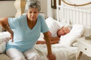 Une femme avec un mal de dos en sortant de son lit